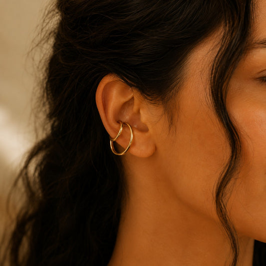 Gemina Ear Cuff Gold am Ohr getragen, moderner Doppelring-Ohrschmuck ohne Ohrloch aus vergoldetem Edelstahl.