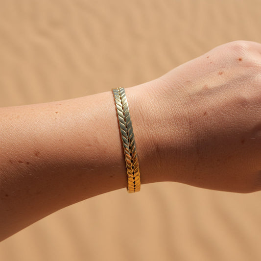 Greca Armreif Gold am Handgelenk getragen, fein strukturierter offener Armreif aus 18K PVD-beschichtetem Edelstahl.