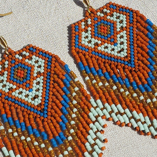 Tangeri Miyuki Statement Ohrringe schräg auf Leinen, geometrisches Muster aus japanischen Delica-Perlen sichtbar.
