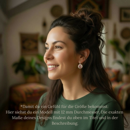 Seitenprofil einer lächelnden Frau mit hochgestecktem Haar, die einen runden Porzellanohrring von EDELATELIER. trägt. Der Ohrring hat einen Durchmesser von 12 mm und zeigt ein filigranes, rosa Blumendekor auf weißem Grund. Das Tragebeispiel verdeutlicht die Proportionen des handgefertigten Upcycling-Schmuckstücks in einer warmen, wohnlichen Umgebung.