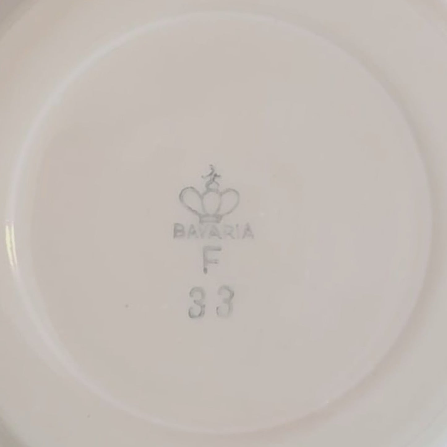 Nahaufnahme der grauen Bodenmarke auf weißem Porzellan: Krone, Schriftzug "BAVARIA F" und Nummer "33".