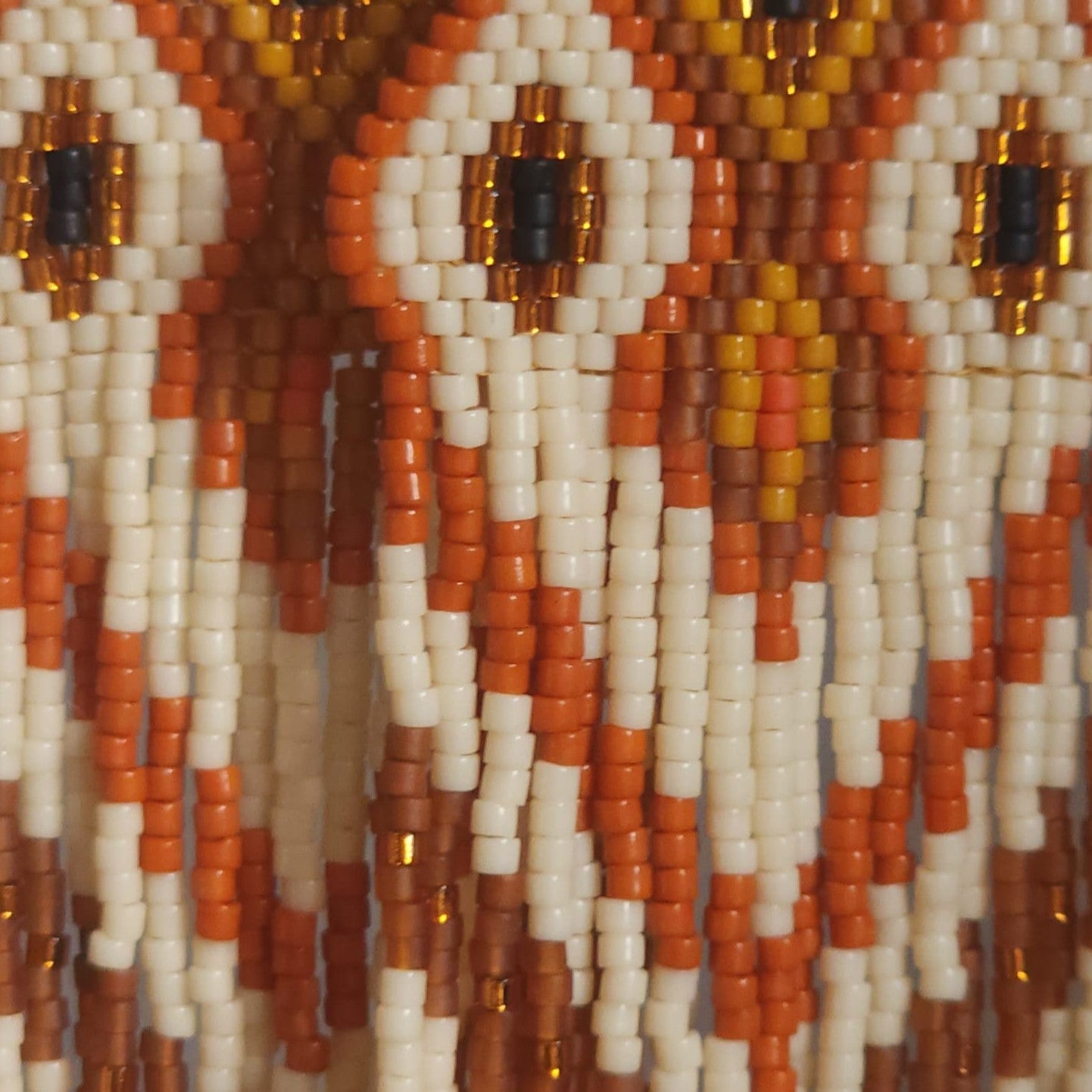 Detaillierte Makroaufnahme des handgewebten Rautenmusters der Ohrringe Fiamma di Terra von EDELATELIER. Die präzise Anordnung der Miyuki-Perlen zeigt ein symmetrisches, geometrisches Design in Natur- und Goldfarben.