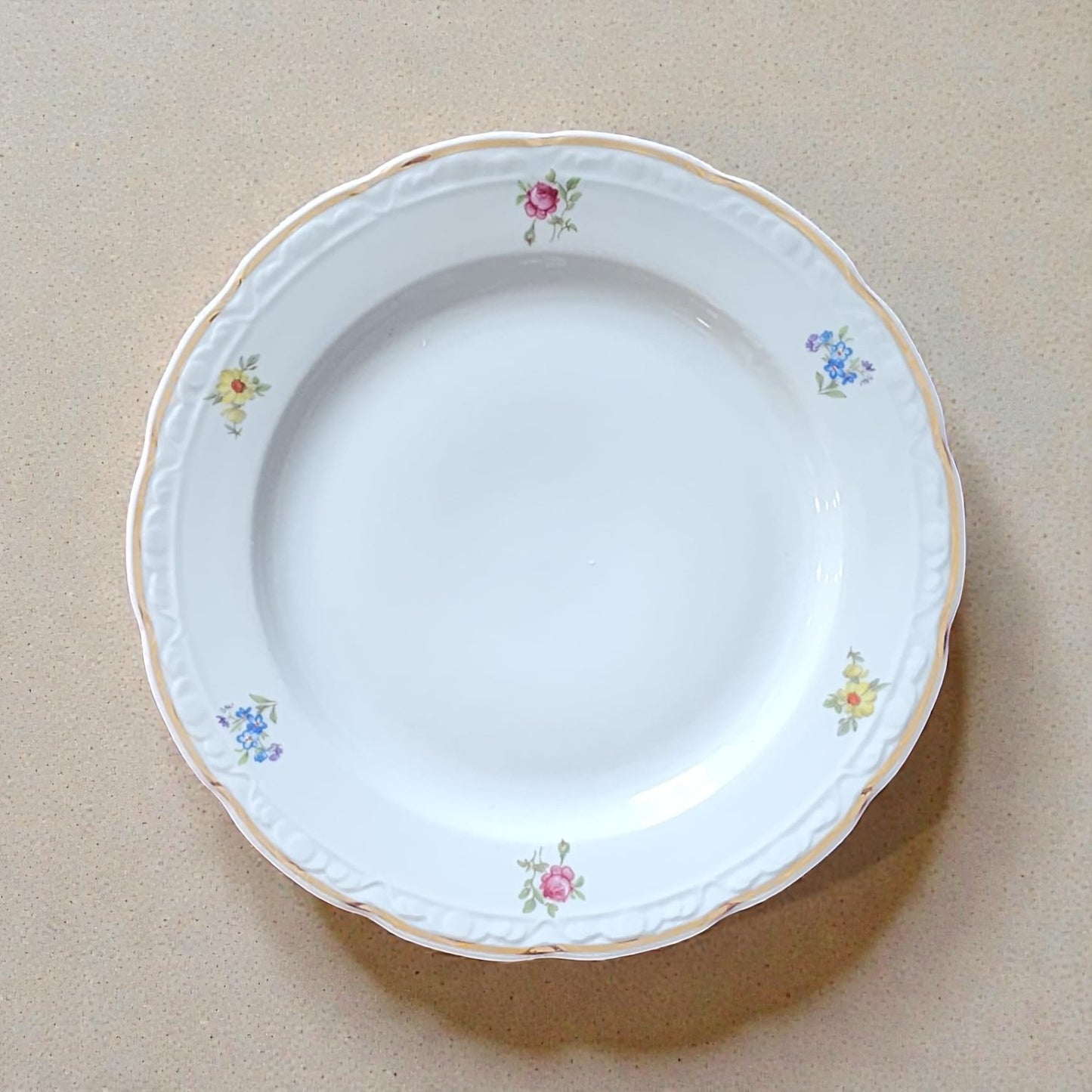 Weißer Vintageteller aus Porzellan mit floralen Mustern und Goldrand vom Edelatelier.