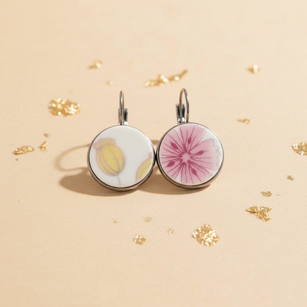 Handgefertigte Porzellanohrringe Amicitia mit kombiniertem Dekor aus gelber Knospe und rosa Blüte auf beigem Hintergrund von EDELATELIER.