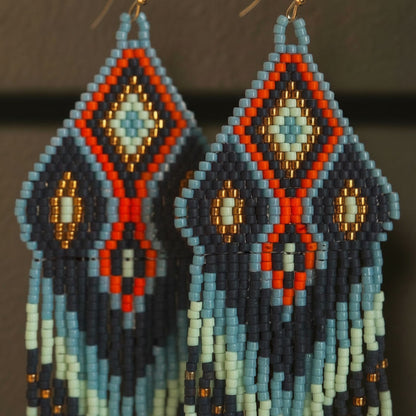 Detaillierte Makroaufnahme des handgewebten Rautenmusters der Ohrringe Arancio Celeste von EDELATELIER. Die präzise Webtechnik mit Miyuki-Perlen kombiniert strahlende Orange-Töne mit kühlem Blau und feinen Goldakzenten.