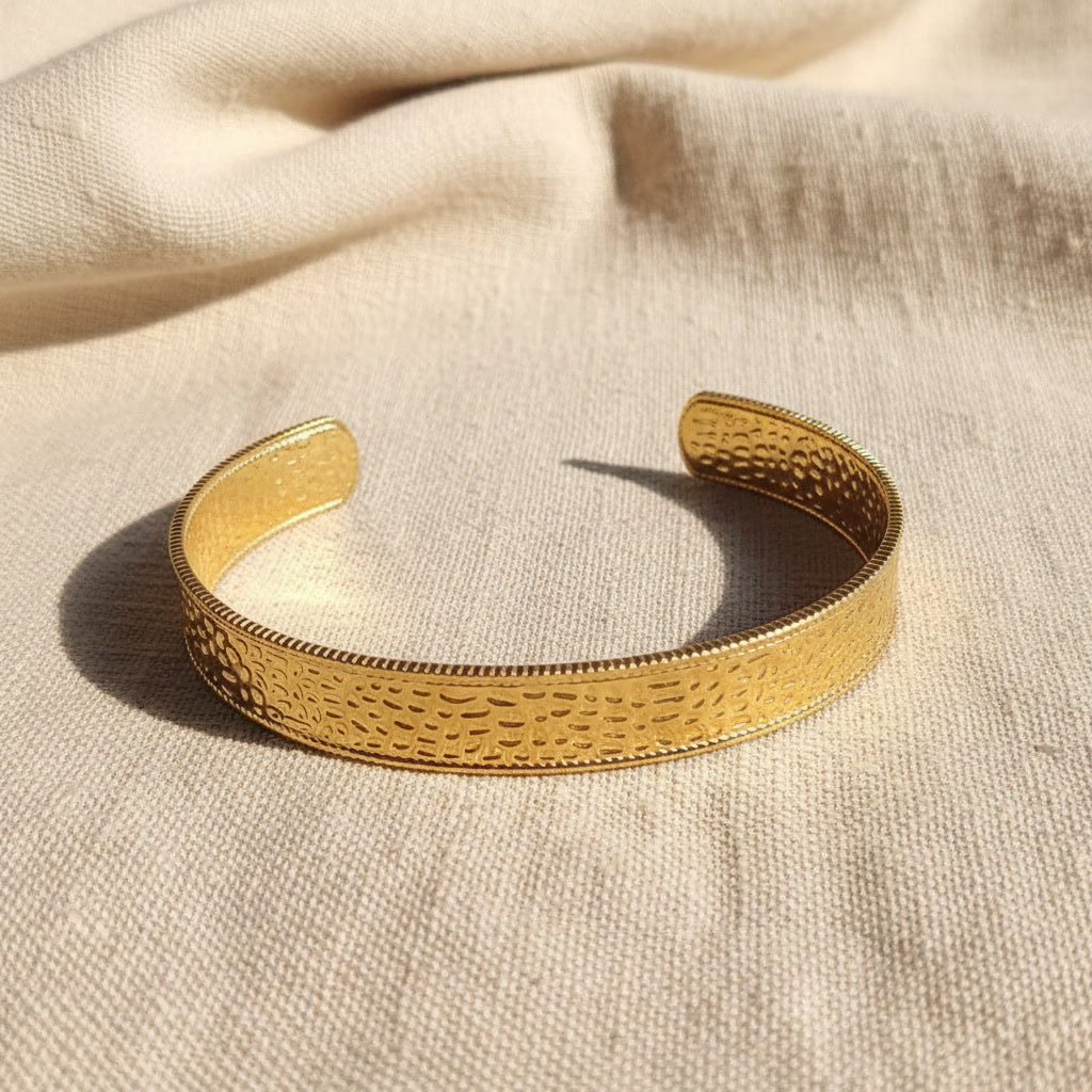 Aurelia breiter gehämmerter Armreif Gold aus 18 Karat PVD-vergoldetem 316L Edelstahl auf beigem Leinen.