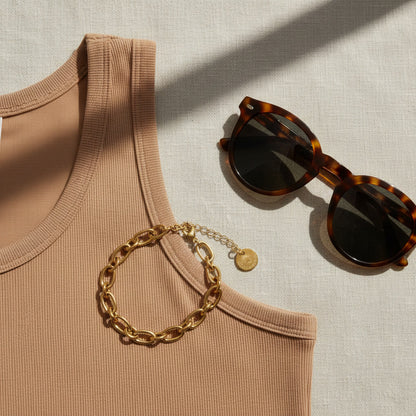 Catena Armband goldfarben auf braunem Top mit Sonnenbrille im Sommerlook.