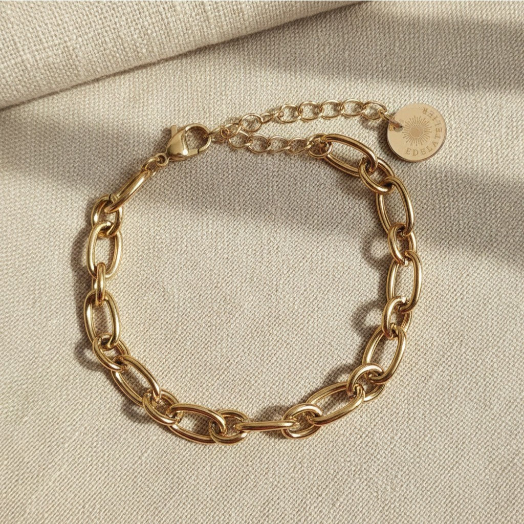 Catena Gliederarmband aus 18 Karat vergoldetem Edelstahl mit EDELATELIER Logo-Plättchen auf hellem Leinenstoff.