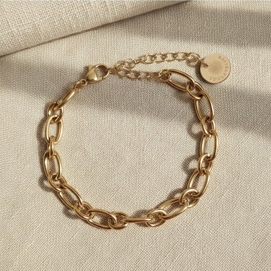 Catena Gliederarmband aus 18 Karat vergoldetem Edelstahl mit EDELATELIER Logo-Plättchen auf hellem Leinenstoff.
