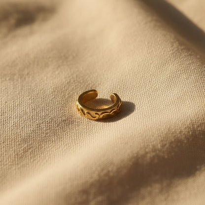 Offener Arabesco Ear Cuff in Gold mit feinem Reliefmuster und sichtbarer Ohrklemmen-Form.