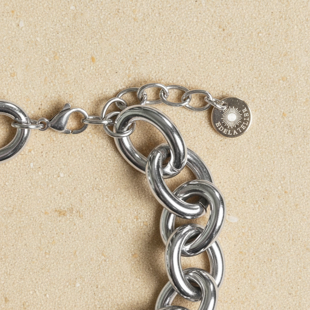 Detailaufnahme des silberfarbenen Bella Chunky Armbands mit Karabiner, Verlängerungskette und EDELATELIER.-Logoplättchen.