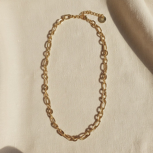 Catena Halskette aus 18 Karat vergoldetem Edelstahl mit ovalen Gliedern auf hellem Leinenstoff.
