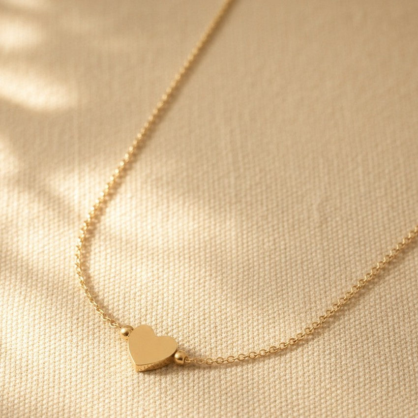 Nahaufnahme der Cuore Halskette mit kleinem Herzanhänger und filigraner goldfarbener Kette