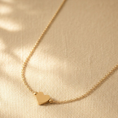 Nahaufnahme der Cuore Halskette mit kleinem Herzanhänger und filigraner goldfarbener Kette