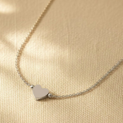 Nahaufnahme der Cuore Halskette mit kleinem silberfarbenem Herzanhänger und filigraner Kette