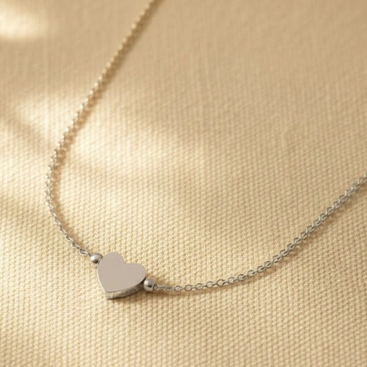 Nahaufnahme der Cuore Halskette mit kleinem silberfarbenem Herzanhänger und filigraner Kette
