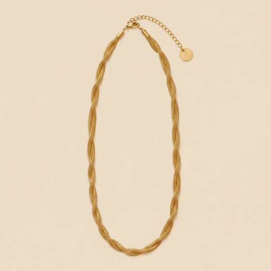 Goldfarbene Intreccia  Halskette mit gedrehter Struktur, Karabiner und Verlängerungskette auf dunklem Hintergrund.