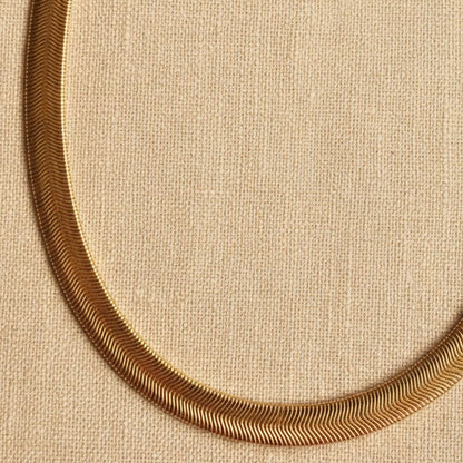 Nahaufnahme der goldfarbenen Serena Halskette mit flacher, fein strukturierter Schlangenkette.