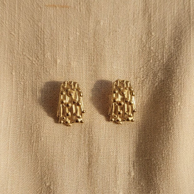 Detailaufnahme der Struttura Ohrstecker mit strukturierter Oberfläche und 18 Karat Gold PVD-Beschichtung.