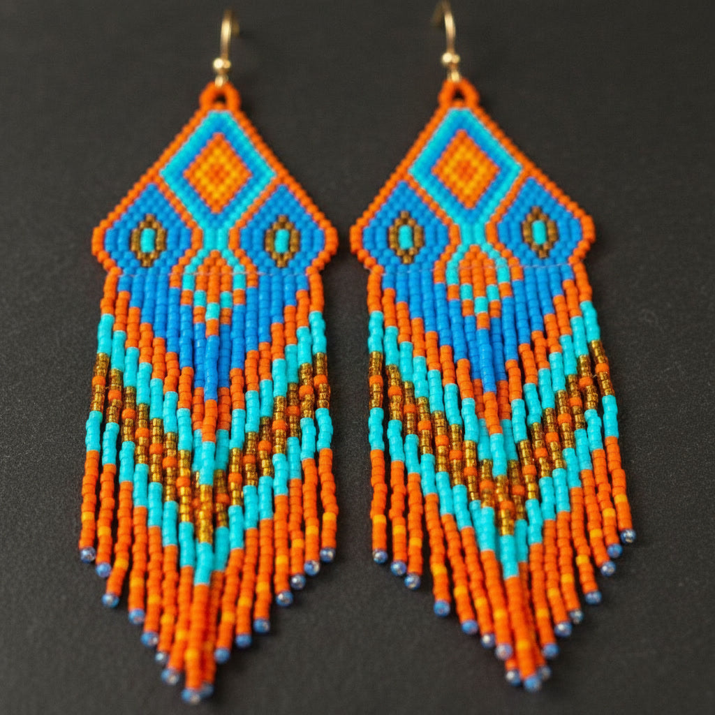 Detaillierte Makroaufnahme des handgewebten Rautenmusters der Ohrringe Fiamma Azzurra von EDELATELIER. Das präzise geometrische Design aus hochwertigen Miyuki-Perlen vereint lebendige Komplementärfarben mit edlen Goldakzenten.