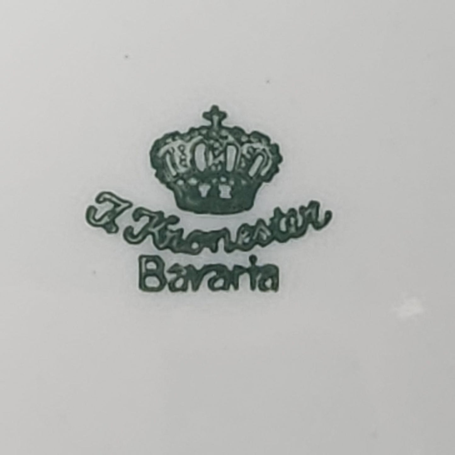 Nahaufnahme der grünen Vintage-Bodenmarke mit Krone und dem Schriftzug J Kronester Bavaria auf weißem Porzellan.