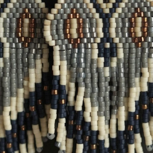 Nahaufnahme der fließenden Perlenfransen des Modells Grigio Eleganza. Die Makro-Ansicht verdeutlicht die feine Textur der handgereihten Miyuki Delica Perlen in Grau und Creme und zeigt die hochwertige Verarbeitung, die jedes Paar von EDELATELIER auszeichnet.