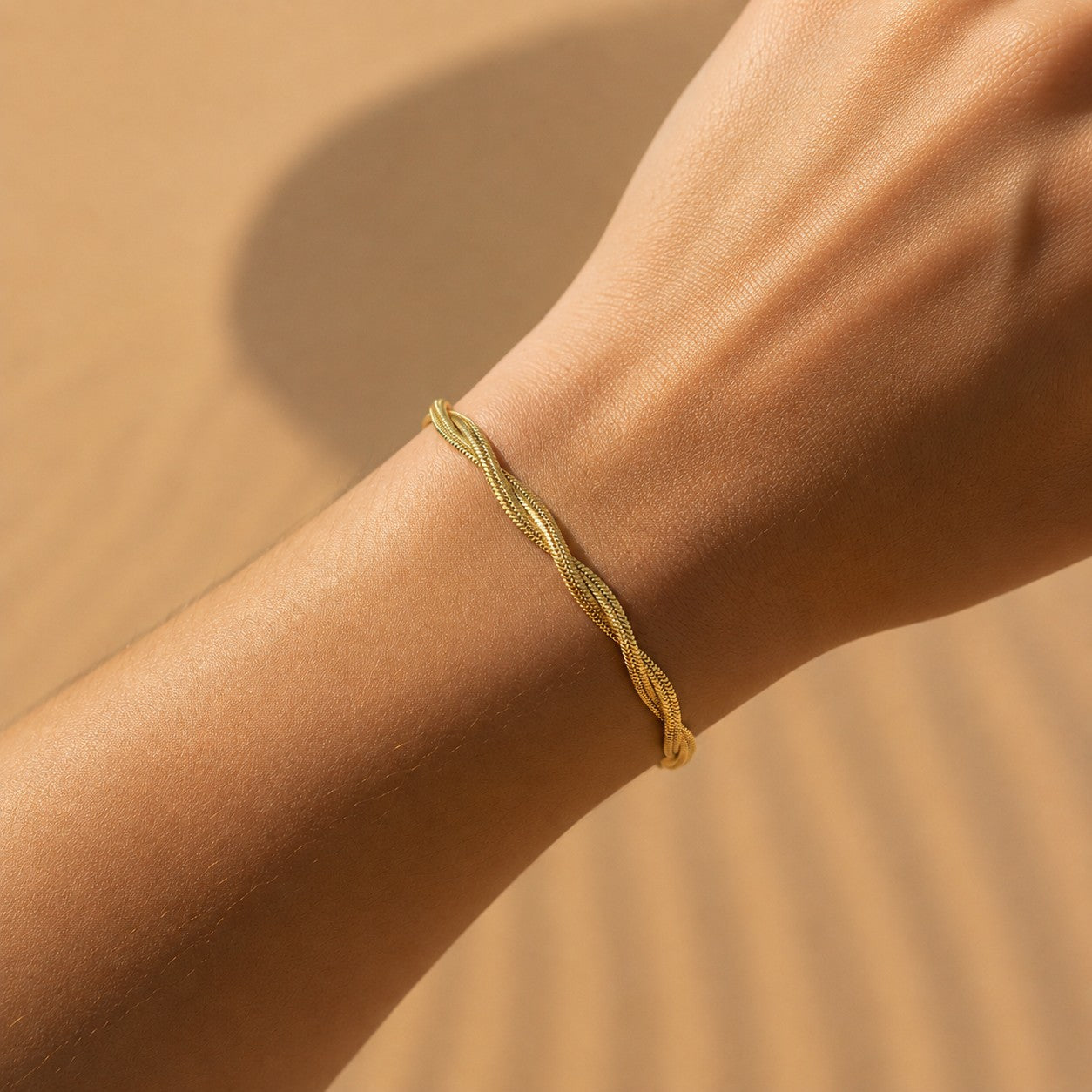 Goldfarbenes Intreccia Armband getragen am Handgelenk.
