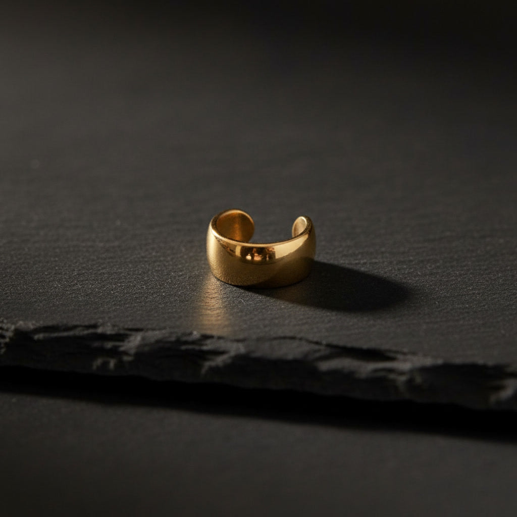 Goldener Luna Ear Cuff aus Edelstahl auf dunklem Hintergrund.