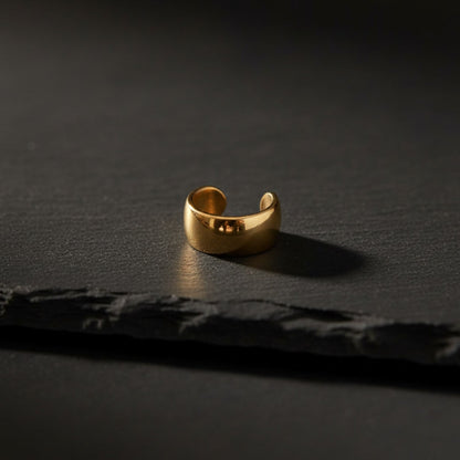 Goldener Luna Ear Cuff aus Edelstahl auf dunklem Hintergrund.