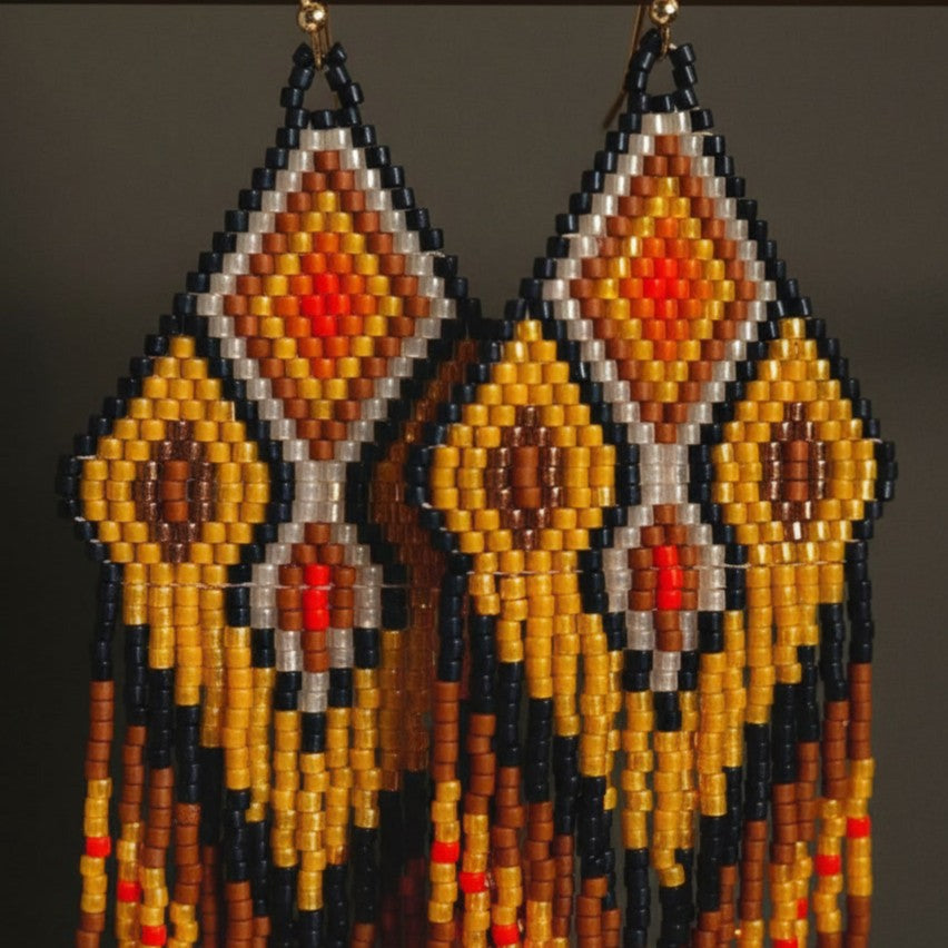 Detaillierte Makroaufnahme des handgewebten Rautenmusters der Ohrringe Ocra Nera von EDELATELIER. Das präzise geometrische Design aus hochwertigen Miyuki-Perlen vereint sattes Ockergelb mit tiefschwarzen Kontrasten und feinen Goldakzenten.