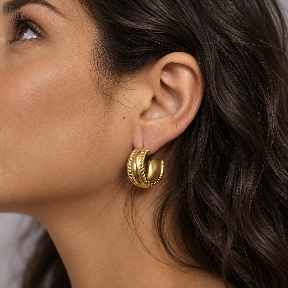 Ornella Chunky Creolen Gold am Ohr getragen, breite Retro-Boho Creolen mit markanter Kordelstruktur.