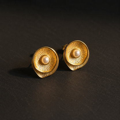 Perla Vintage-Ohrringe in Goldoptik mit runder Perle auf dunklem, edlem Hintergrund.