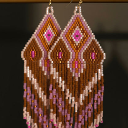 Detaillierte Makroaufnahme des handgewebten Rautenmusters der Statement-Ohrringe Rosa Canella von EDELATELIER. Die Komposition aus matten Miyuki-Perlen in sanftem Rosé, warmem Braun und goldenen Akzenten zeigt die hochwertige Handwerkskunst und die feine Struktur des Webmusters.