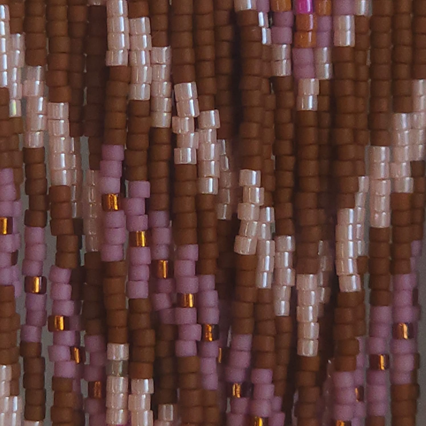 Nahaufnahme der fließenden Perlenfransen des Modells Rosa Canella. Die Makro-Ansicht zeigt die feine Textur und den weichen Fall der handgereihten Miyuki Delica Perlen in Rosé- und Zimttönen. Ein authentischer Einblick in die filigrane und ehrliche Handarbeit von EDELATELIER.