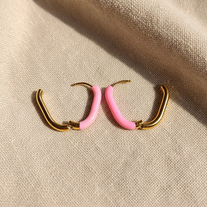 Geöffnete Rosa Creolen Gold Rosa mit sichtbarem Klappverschluss auf beigem Leinen.