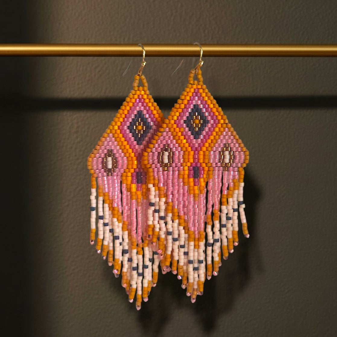 Handgewebte Perlenohrringe Rosato Flair von EDELATELIER an einer goldenen Stange. Das Design besticht durch seinen sanften Farbverlauf in Rosé und Gold sowie die extralangen, fließenden Perlenfransen.