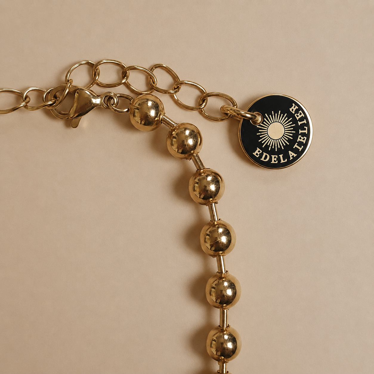 Detailaufnahme des Sfera Armbands mit Karabinerverschluss, Verlängerungskette und EDELATELIER-Logoplättchen.