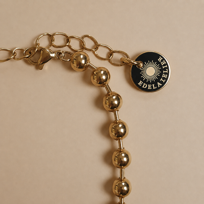 Detailaufnahme des Sfera Armbands mit Karabinerverschluss, Verlängerungskette und EDELATELIER-Logoplättchen.