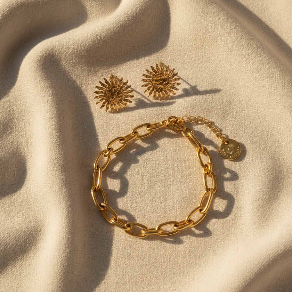Solina Sonnenohrringe kombiniert mit goldenem Armband auf hellem Stoff.