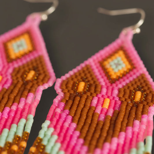 Extreme Makro-Nahaufnahme der handgewebten Miyuki-Perlen von EDELATELIER., die die präzise Anordnung der altrosafarbenen und goldenen Perlen im Detail des Modells Tropica Rosa zeigt.