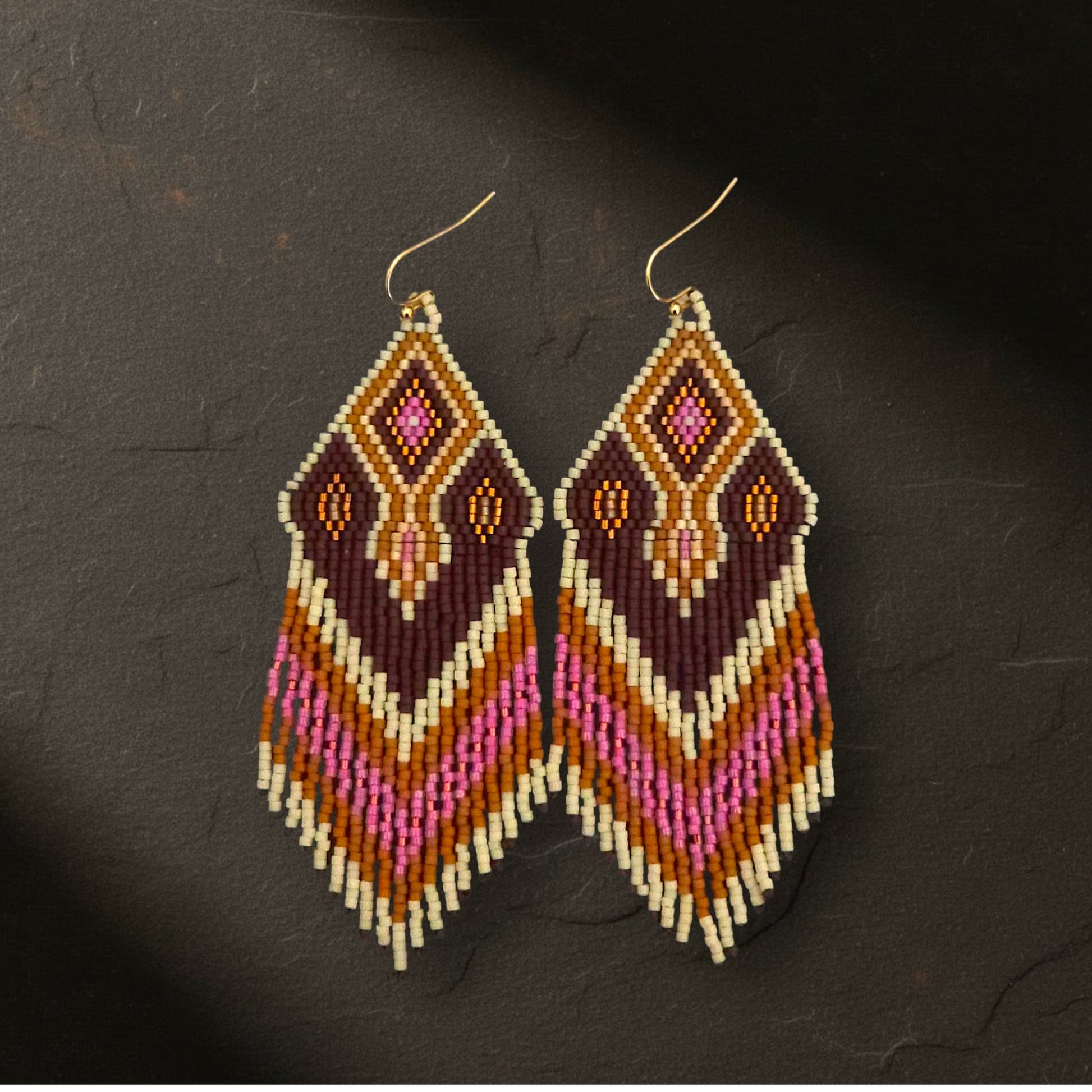 Detaillierte Makroaufnahme des handgewebten Rautenmusters der Ohrringe Wine Aurora von EDELATELIER. Das präzise geometrische Design aus Miyuki-Perlen kombiniert dunkle Edelsteinfarben mit strahlenden Pink-Akzenten und feinen Golddetails.
